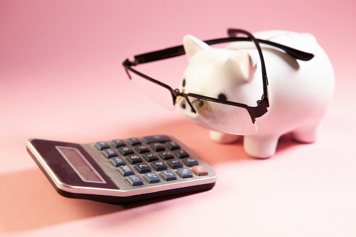 a calculator and a piggy bank wearing glasses